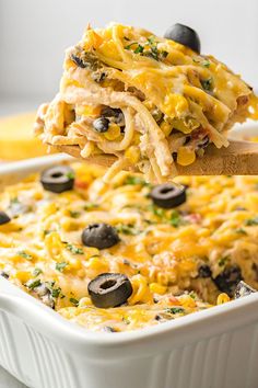 a casserole dish filled with chicken, black olives and cheese