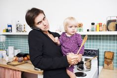 a woman holding a child in the kitchen