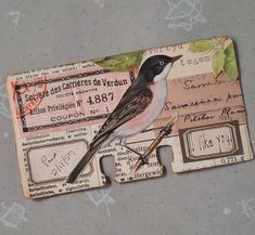 a bird sitting on top of a piece of paper that has been cut out to look like a ticket