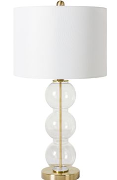 a table lamp with three glass balls on the base and a white lampshade