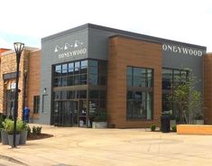 an empty parking lot in front of a one - way wood building with large windows