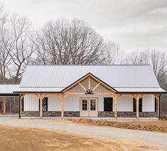 a large white building sitting on top of a dirt road