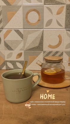 a cup of tea sitting on top of a wooden table next to a jar of honey