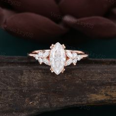 an oval cut diamond ring on top of a piece of wood