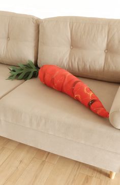 a large carrot laying on top of a couch