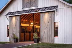 a white barn with wooden doors and windows