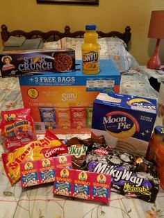 a bed topped with lots of different types of snacks