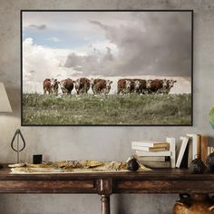 a herd of cows grazing on a lush green field under a cloudy sky