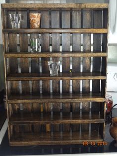 a wooden shelf filled with glasses on top of a counter