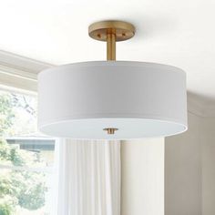 a white lamp hanging from the ceiling in a living room