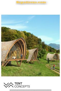 an image of some kind of wooden structure in the middle of a green field with people walking around it