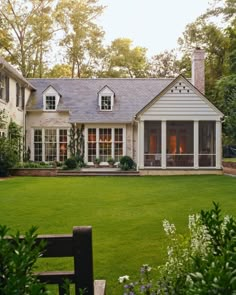 a large white house sitting on top of a lush green field