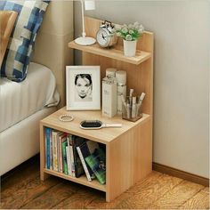 a bedroom with a bed, nightstand and bookshelf on the floor next to it