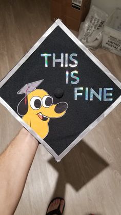 a person wearing a graduation cap that says this is fine