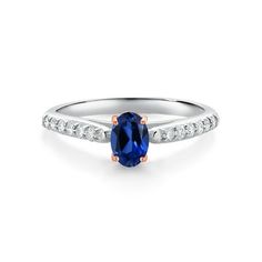 an oval blue sapphire and diamond ring on a white background, with the top stone set in