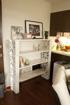 a living room filled with furniture and pictures on the wall next to a kitchen counter