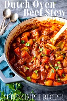 the dutch oven beef stew is ready to be eaten with a wooden spoon in it