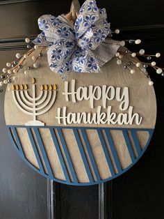 a happy hanukkah sign hanging on the front door with a large bow