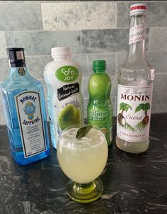 various alcoholic drinks are lined up on a counter top, including lemonade and gin