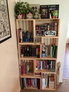 a bookshelf filled with lots of books next to a wall