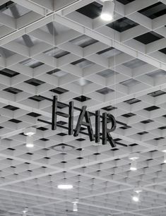 the letters fair are suspended from the ceiling in an open space with black and white tiles