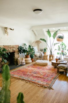 a living room filled with lots of plants next to a fire place and couches