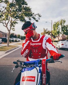 a man in red and white is talking on his cell phone while riding a bike