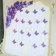 purple and pink butterflies are arranged on a white board