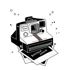 an old polaroid camera sitting on top of some papers