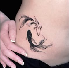 a woman's stomach with a fish tattoo on it