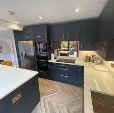 a kitchen with gray cabinets and white counter tops