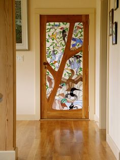 the door is decorated with colorful birds and tree designs on it's glass panels