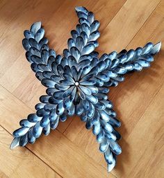 a metal snowflake sitting on top of a wooden floor