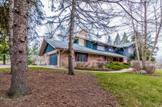 a large house in the middle of some trees and grass with no leaves on it