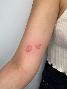 a woman with a tattoo on her arm that has two butterflies in the shape of hearts