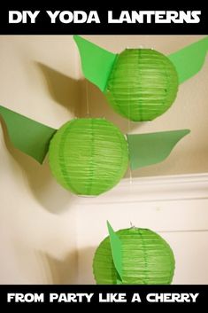 two green paper birds hanging from the ceiling with text that reads diy yoda lanterns from party like a cherry