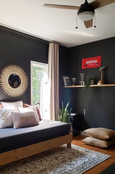 a bed room with a neatly made bed next to a window and a ceiling fan