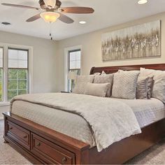 a large bed sitting in a bedroom next to two windows