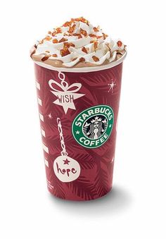 a starbucks drink with whipped cream and christmas decorations