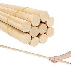 a stack of wood sticks and a person's hand with a stick in front of them