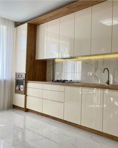 a kitchen with white cabinets and marble counter tops, along with an oven in the center