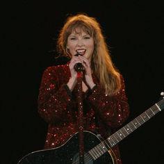 a woman singing into a microphone while holding a guitar