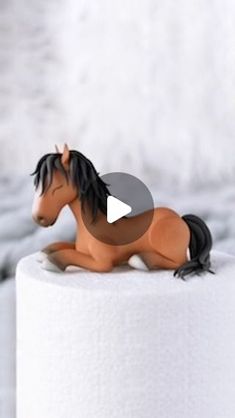 a toy horse laying on top of a toilet paper roll