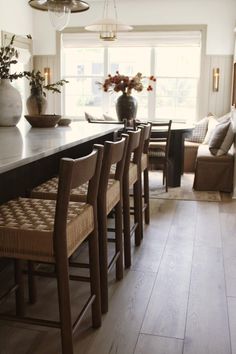 a dining room table and chairs in front of a window