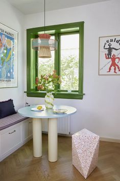 a room with a table, window and bench in it