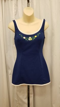 Vintage Catalina 60's Playsuit Swimsuit One Piece Navy Blue w White Trim & Embroidered Flowers Bathing Suit Beachwear Romper Poolside Swimwear Made in USA.  Swimwear is in excellent condition - (see pics).  Fabric does stretch!  The shoulder straps are adjustable. Skirt covers the bottom swimsuit area.  Inside bra has built in support. Measurements: waist 28, bust 34, front length from top of shoulder strap to crotch 29, length shoulder strap to bottom of skirt 25 1/2, shoulder to shoulder 13 1/ 60s Bathing Suit, 80s Swimwear, 1960s Swimwear, 50s Bathing Suit, 80s Swimsuit, Adjustable Skirt, Vintage Playsuit, Modest Bathing Suit, Feminine Wardrobe