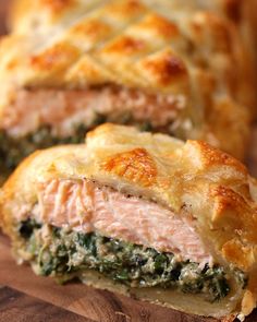 meat and spinach pie cut in half on a cutting board