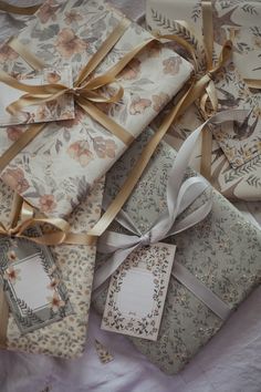 several wrapped gift boxes with ribbons and tags on them, all decorated in floral patterns