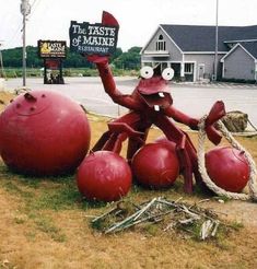 a large red crab sitting on top of two giant red balls