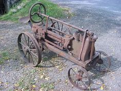 an old rusted out tractor sitting on the ground